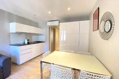 a kitchen and dining room with a table and chairs at Stylish 2 Bed Apartment 1 Min to Palais & Beach in Cannes