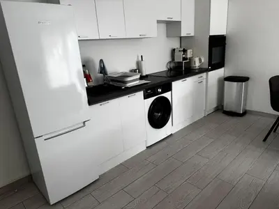 a kitchen with white cabinets and a washer and dryer at 3-room apartment with sea view in Cannes in Cannes