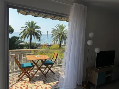 a balcony with a table and chairs and a view of the ocean at 3-room apartment with sea view in Cannes in Cannes