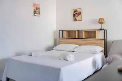 a bedroom with a white bed with two towels on it at Studio rénové avec grande terrasse - Climatisation - Aperçu mer in Cannes