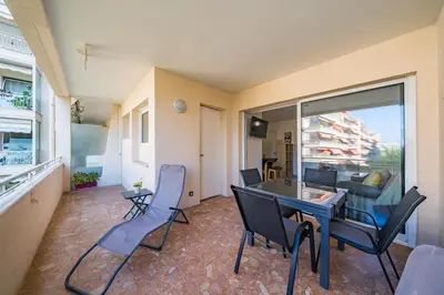 a living room with a table and chairs and a view at Studio rénové avec grande terrasse - Climatisation - Aperçu mer in Cannes