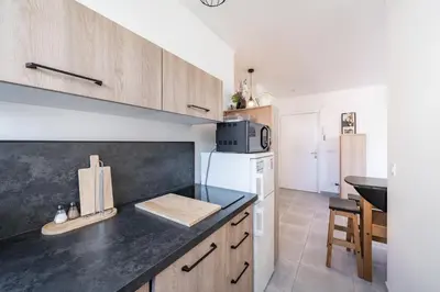 a kitchen with wooden cabinets and a counter top at Studio rénové avec grande terrasse - Climatisation - Aperçu mer in Cannes
