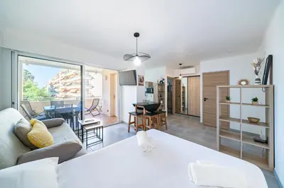a living room with a couch and a kitchen at Studio rénové avec grande terrasse - Climatisation - Aperçu mer in Cannes