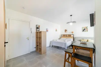 a bedroom with a bed and a desk and a table at Studio rénové avec grande terrasse - Climatisation - Aperçu mer in Cannes