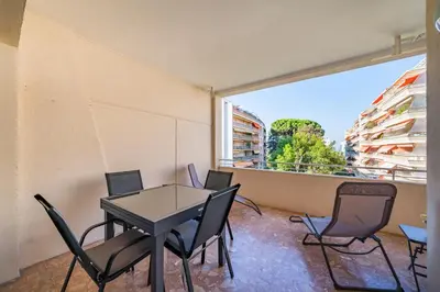 a room with a table and chairs and a large window at Studio rénové avec grande terrasse - Climatisation - Aperçu mer in Cannes