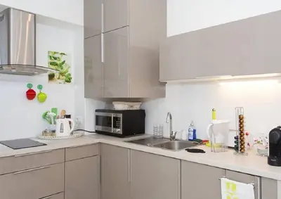a white kitchen with a sink and a microwave at Mont Chevalier by Welcome to Cannes in Cannes