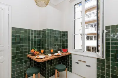 a green tiled bathroom with a table and two green stools at Yello YourHostHelper in Cannes