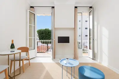 a living room with a table and chairs and a tv at Yello YourHostHelper in Cannes
