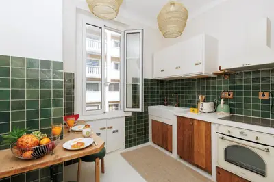 a kitchen with green tiles and a table with a bowl of fruit at Yello YourHostHelper in Cannes