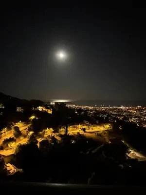 a full moon rising over a city at night at Stunning 3-Room with Panoramic Views Over Cannes in Le Cannet