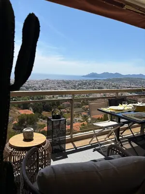 a balcony with a table and chairs and a view at Stunning 3-Room with Panoramic Views Over Cannes in Le Cannet