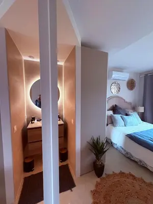 a bedroom with a bed and a vanity and a mirror at Stunning 3-Room with Panoramic Views Over Cannes in Le Cannet