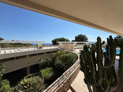 a view from the balcony of a resort with a cactus at Stunning 3-Room with Panoramic Views Over Cannes in Le Cannet
