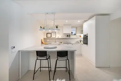 a kitchen with a large island with two bar stools at Charme et confort à Cannes près de la Croisette in Cannes