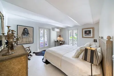 a bedroom with a large white bed and some windows at Charme et confort à Cannes près de la Croisette in Cannes