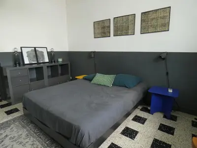 a bedroom with a bed and a blue table at Cannes - LE DOLCE appartement de charme - 3 chambres - piscine in Cannes
