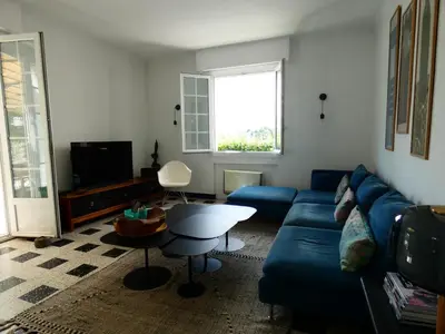 a living room with a blue couch and a table at Cannes - LE DOLCE appartement de charme - 3 chambres - piscine in Cannes