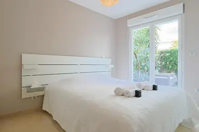 a white bedroom with a large bed with towels on it at Le Maria by Winsome Destination in Cannes