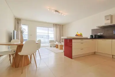 a kitchen with a table and white chairs and a table and a counter at Le Maria by Winsome Destination in Cannes