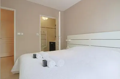a bedroom with a white bed with two rolled towels at Le Maria by Winsome Destination in Cannes