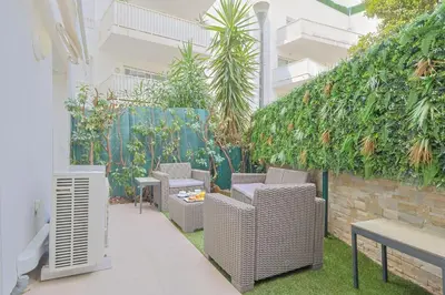 a patio with wicker chairs and a wall with plants at Le Maria by Winsome Destination in Cannes