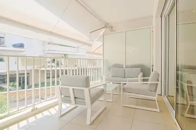 a room with white chairs and a table and windows at Le Maria by Winsome Destination in Cannes