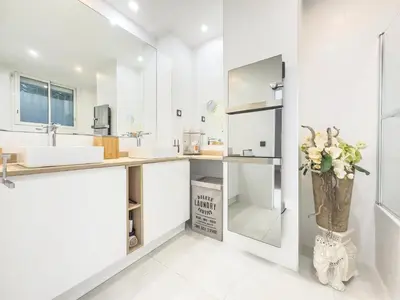 a white bathroom with a sink and a mirror at Le KamS in Cannes