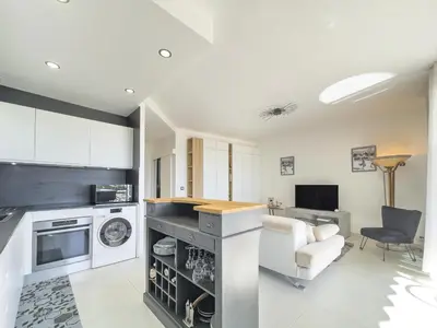 a living room with a kitchen and a living room with a couch at Le KamS in Cannes