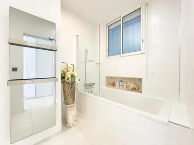 a bathroom with a shower and a vase with flowers at Le KamS in Cannes
