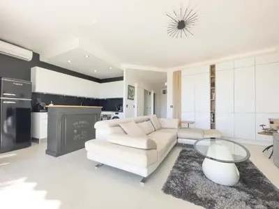 a living room with a white couch and a table at Le KamS in Cannes