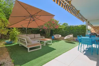 a patio with a couch and a table and an umbrella at Le Val Joli by Winsome Destination in Cannes