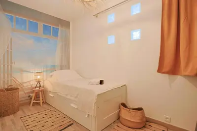 a white bedroom with a bed and a window at Le Val Joli by Winsome Destination in Cannes