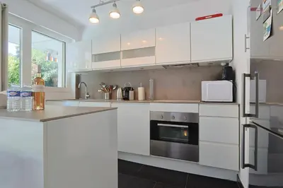 a kitchen with white cabinets and a stove top oven at Le Val Joli by Winsome Destination in Cannes
