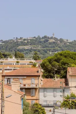 a group of buildings on a hill with trees at Cannes 2 pièces lumineux terrasse ensoleillée in Cannes