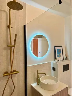 a bathroom with a sink and a round mirror at Studio lumineux 5 minutes Croisette et rue Antibes in Cannes
