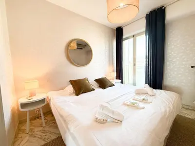 a bedroom with a large white bed with towels on it at Sea View Apartment - Croisette in Cannes