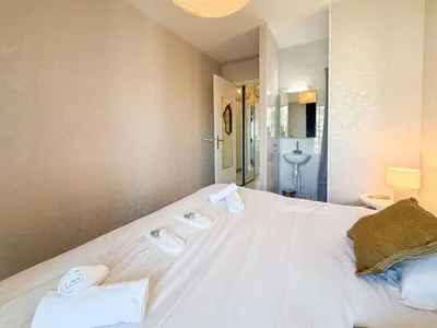 a bedroom with a large white bed and a chair at Sea View Apartment - Croisette in Cannes