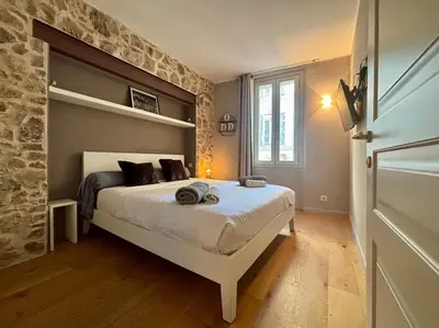 a bedroom with a bed and a stone wall at Cozy 1 Bedroom apartment hypercentre in Cannes