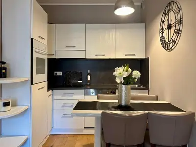 a kitchen with a table with a vase of flowers on it at Cozy 1 Bedroom apartment hypercentre in Cannes