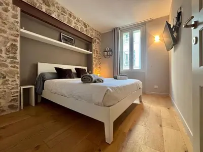 a bedroom with a bed with a stone wall at Cozy 1 Bedroom apartment hypercentre in Cannes