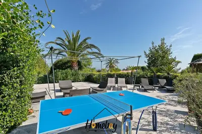 a ping pong table and chairs on a patio at Villa Rose Pool Sea View Super Cannes in Vallauris