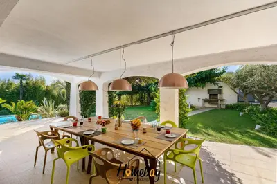 a dining room with a wooden table and chairs at Villa Rose Pool Sea View Super Cannes in Vallauris
