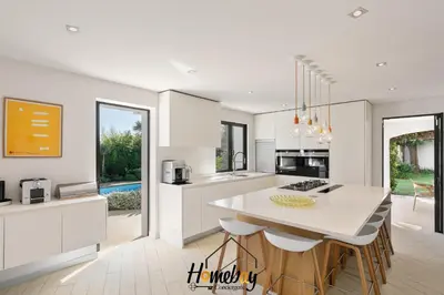 a kitchen with white cabinets and a large white table at Villa Rose Pool Sea View Super Cannes in Vallauris