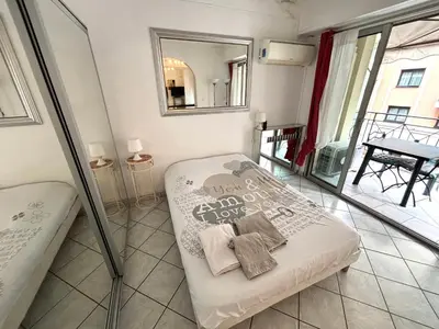 a small bedroom with a bed and a mirror at 2 pieces 50 metres des plages in Cannes