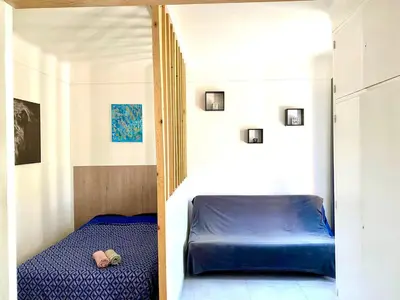 a small bedroom with a blue bed in a room at Appartement Le Central Park in Le Cannet