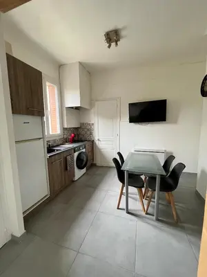 a small kitchen with a table and chairs in it at Appartement Le Central Park in Le Cannet