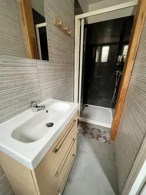 a bathroom with a sink and a bath tub at Appartement Le Central Park in Le Cannet