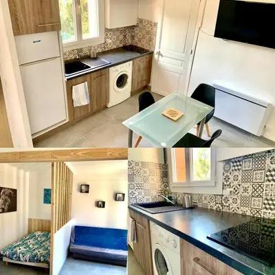 a kitchen with a sink and a table in it at Appartement Le Central Park in Le Cannet