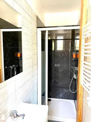 a bathroom with a tub and a sink and a mirror at Appartement Le Central Park in Le Cannet