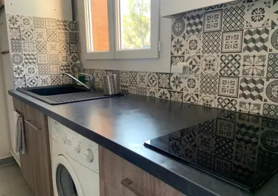 a kitchen with a sink and a washing machine at Appartement Le Central Park in Le Cannet